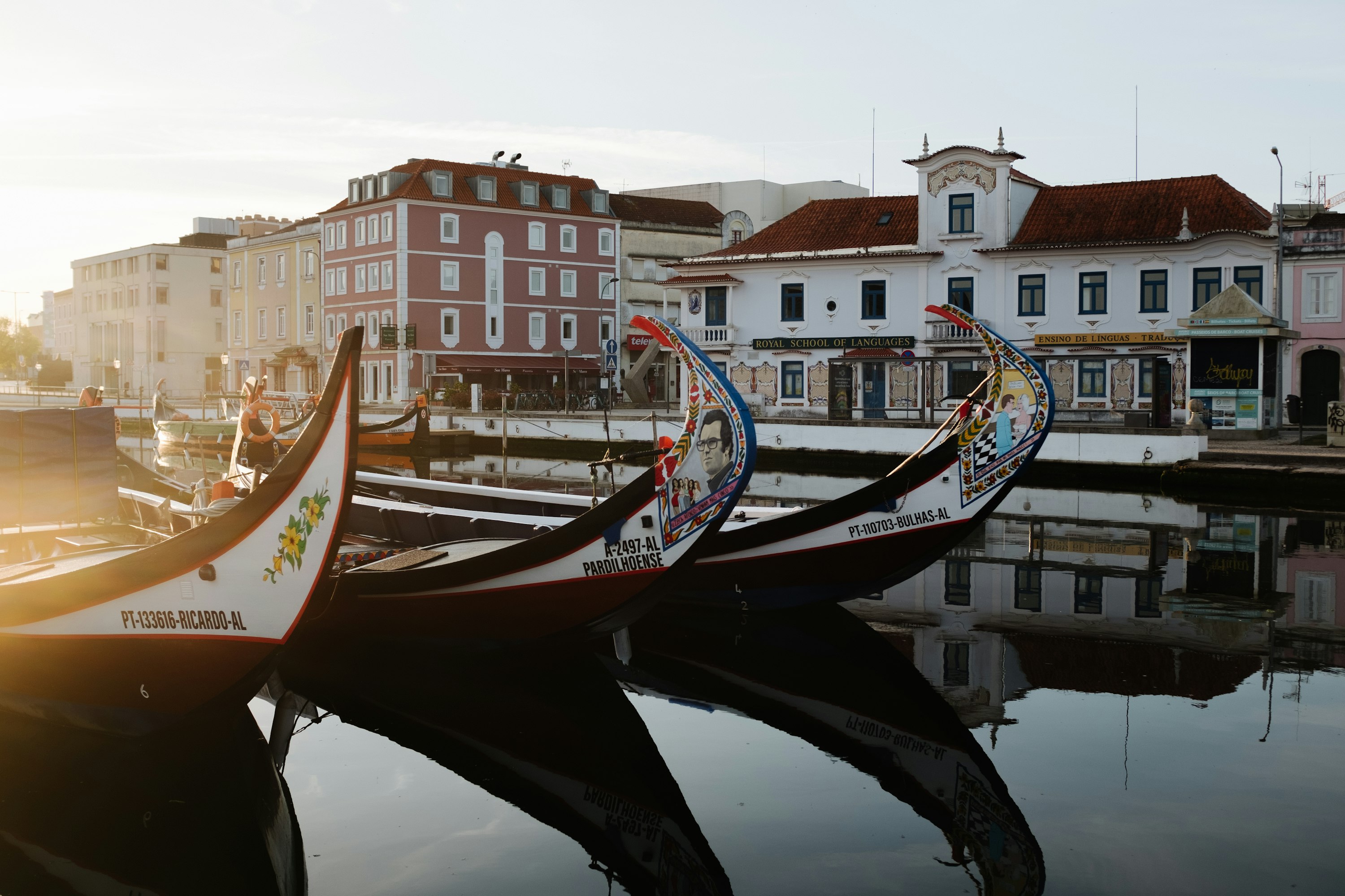 A row of boats sitting next to each other on the canal in Aveiro